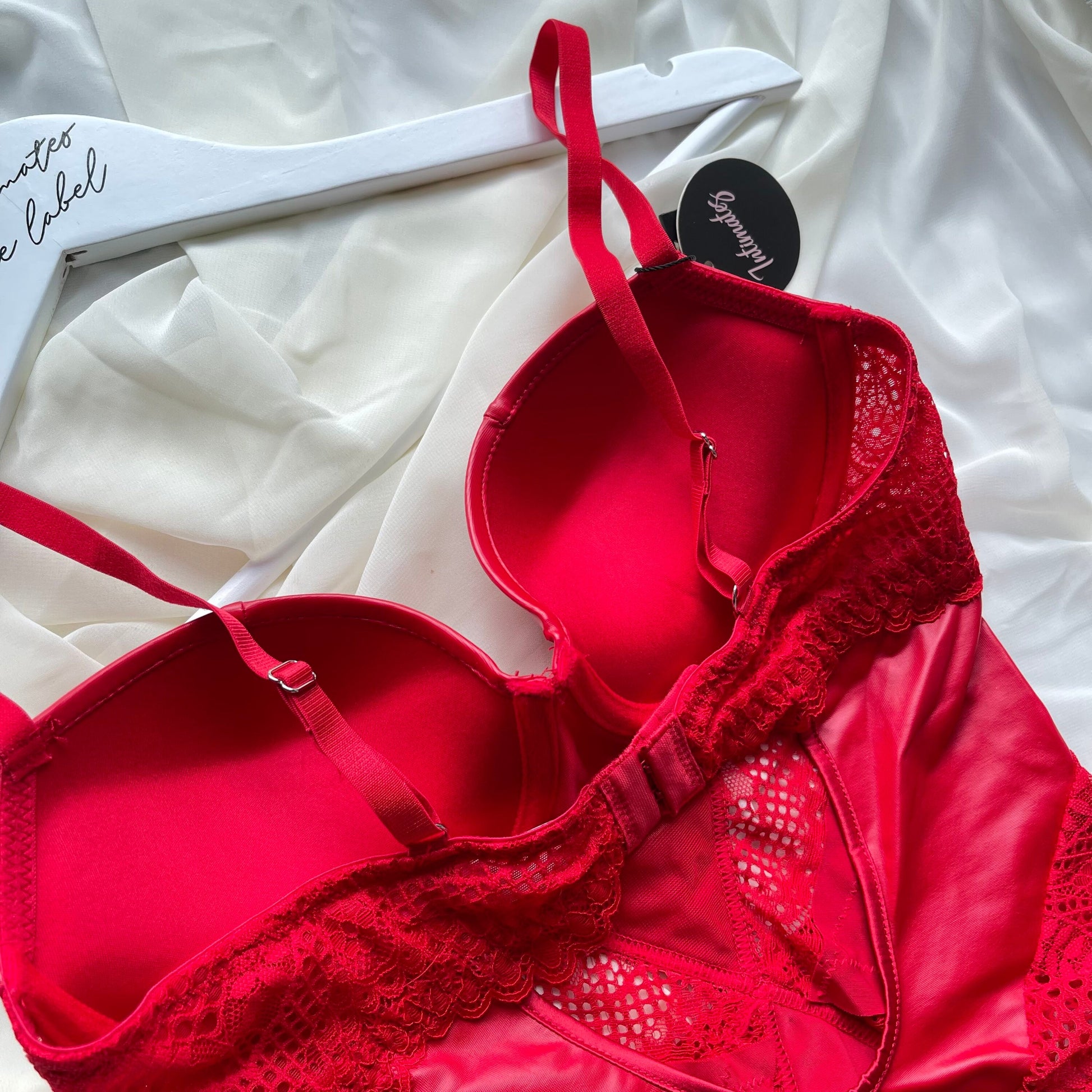 Close-up of the red Noir Sculpt Bodysuit by Undone, showcasing its fitted design and textured fabric details.