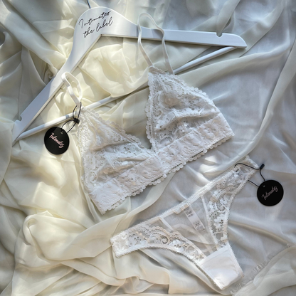 Undone white lace wireless lingerie set with delicate floral patterns, featuring a matching bra and panties for bridal or special occasions.