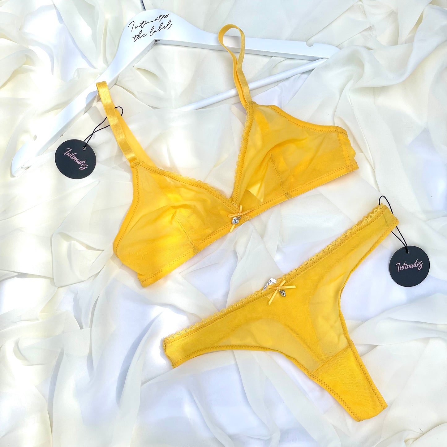 Yellow bra and panties set on a white fabric background 