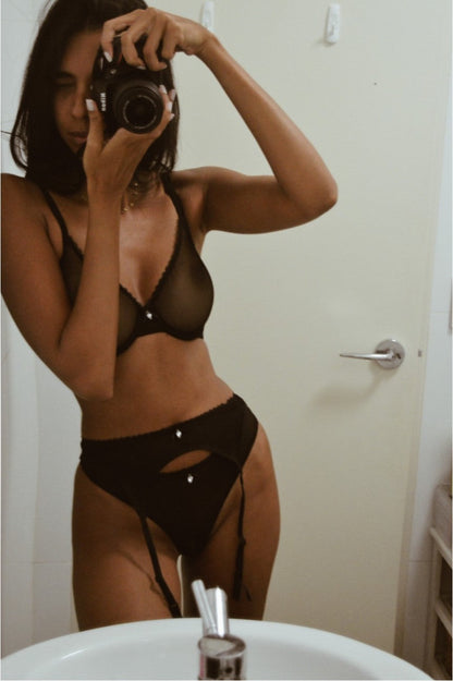 Undone black lingerie set with sheer G-string and suspender, featuring delicate lace details and a flattering fit.